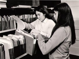 Photo of two women in file room.