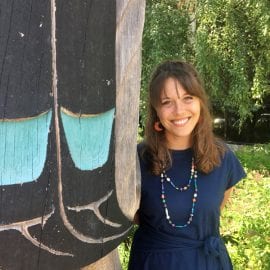 Photo of Elizabeth "Hopey" Fink next to totem pole