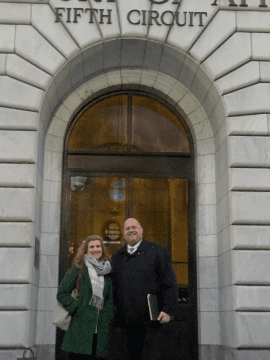 a woman and a man standing in front of courthouse door