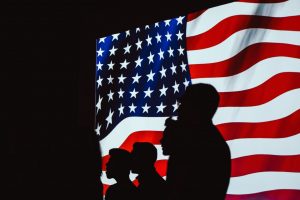 Sihouettes of people on US flag. Credit: Brett Sayles
