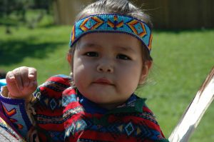 Close-up photo of toddler in Native American regalia and beaded headband